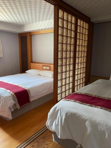 um quarto com 2 camas e uma janela em Mei Hua Hotel em Kaohsiung