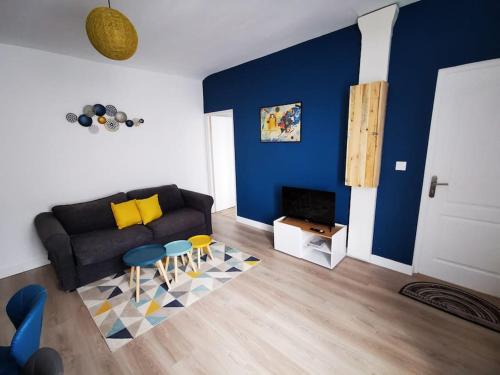 een woonkamer met een zwarte bank en een blauwe muur bij Le Puzzle in Trélazé