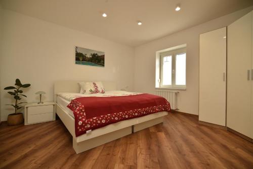 a bedroom with a bed with a red blanket at SEDAMI in Maribor