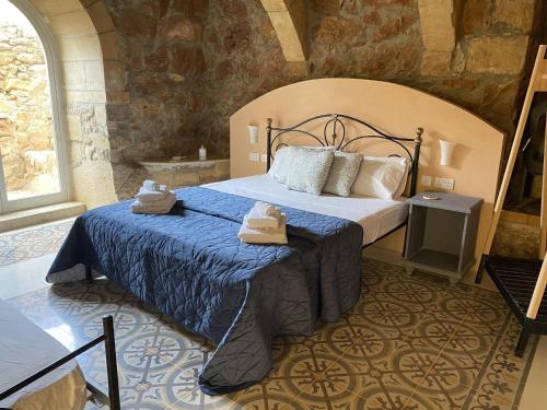 a bedroom with a large bed in a stone room at Ta' Tereza in Xagħra