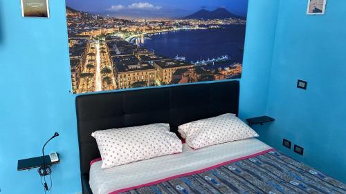 una camera da letto con un grande quadro sopra un letto di Na tazzulel e cafe a Napoli