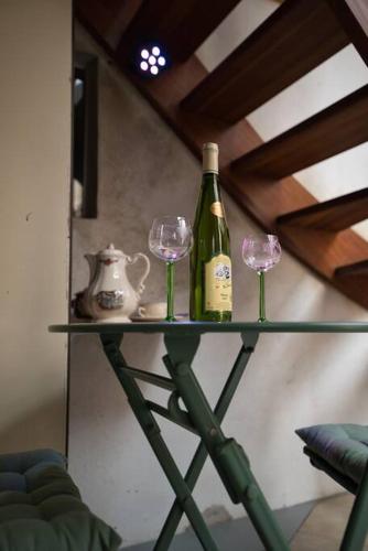 a shelf with two glasses and a bottle of wine at Les Chouchous du Ried 3 / Proche Europapark in Saasenheim