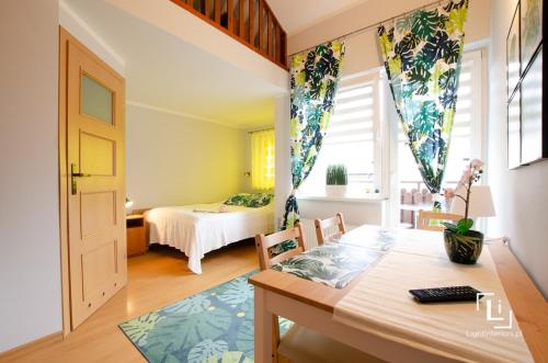 a bedroom with a bed and a table in a room at Pokoje Grażyna in Jastarnia