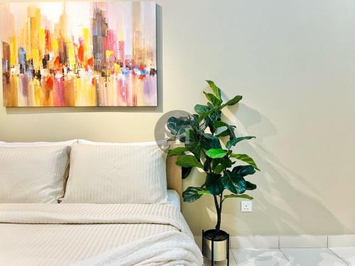 a bedroom with a bed and a painting on the wall at Alanis Suite With Netflix @ KLIA Sepang in Sepang