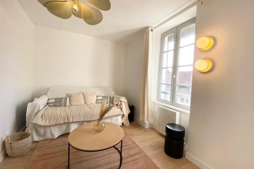 a small bedroom with a bed and a table at Old Port - Terrace with exceptional view! in La Rochelle