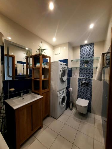a bathroom with a washing machine and a sink at Przestronny Apartament Happy 7 in Warsaw