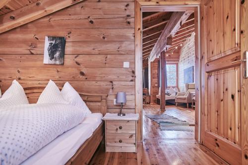 1 dormitorio con 1 cama y pared de madera en MOUNTAINRANGER - Lodge, en Obertauern