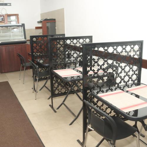 a row of black chairs and tables in a restaurant at HÔTEL TAJ in Antananarivo