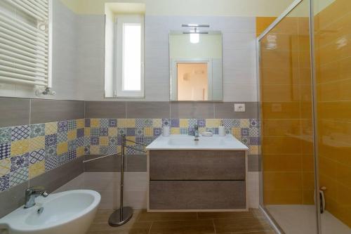 La salle de bains est pourvue d'un lavabo, d'un miroir et d'une douche. dans l'établissement Ischia Riva House Apartament, à Ischia