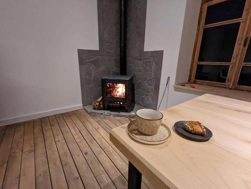 a room with a stove with a table and a cup of coffee at Dsegh Village House in Dsegh