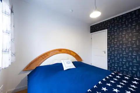 een kamer met een blauw bed met een bedsprei met Amerikaanse vlag bij Villa Vilu in Naantali