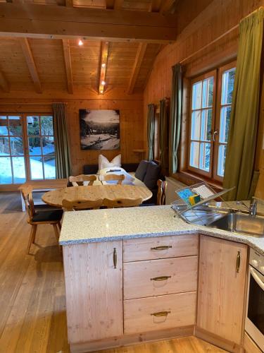 eine Küche und ein Wohnzimmer mit einem Tisch in einer Hütte in der Unterkunft MOUNTAINRANGER - Lodge in Obertauern