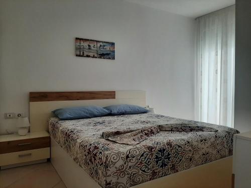 a bedroom with a bed and a window at Kela Apartment 3 in Sarandë