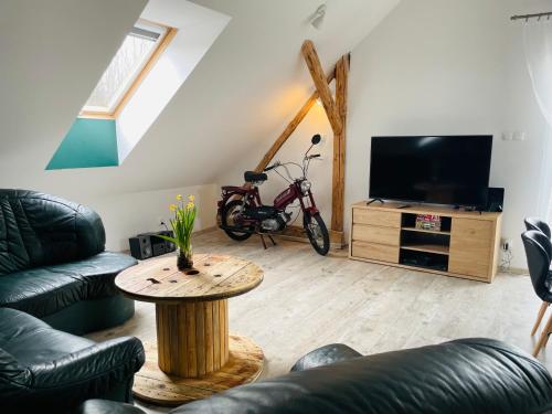 a living room with a table and a tv at Apartamenty Happy & Relax in Bielsko-Biała