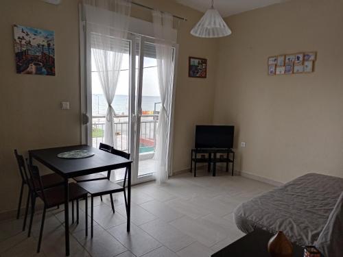 新普拉亞的住宿－Katerina apartment，客房设有桌子、床和桌椅。