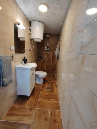 a bathroom with a white sink and a toilet at Nora 2 in Sremska Mitrovica