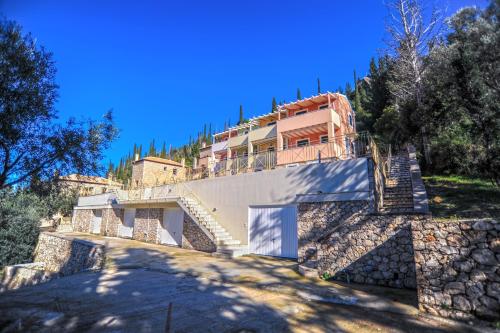 a house on a hill with stairs leading up to it at Agios Nikitas View in Agios Nikitas