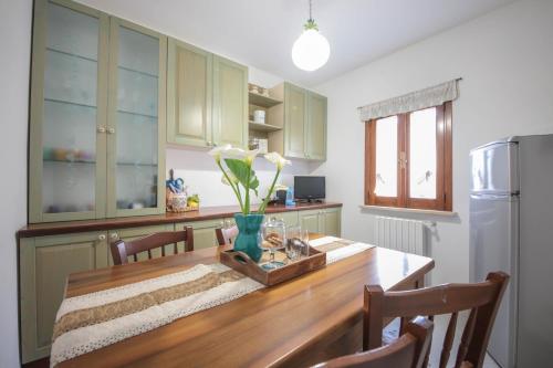 a kitchen with a wooden table and a refrigerator at C'era Una Volta in Monopoli