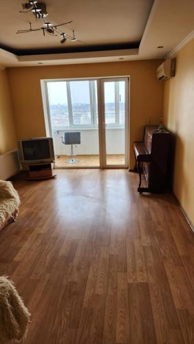 a living room with a wooden floor and a flat screen tv at Трикімнатна квартира зі всіма зручностями in Vilʼshanka