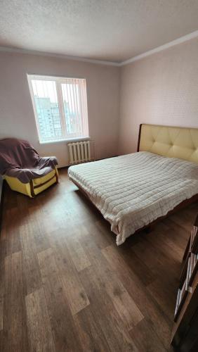 1 dormitorio con 1 cama grande y suelo de madera en Трикімнатна квартира зі всіма зручностями, en Vilʼshanka