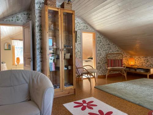 a living room with a couch and a glass cabinet at Pelle Åbergsgården in Nordingrå