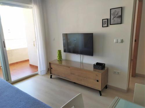 ein Wohnzimmer mit einem Flachbild-TV auf einer Kommode in der Unterkunft El Racó in Canet d'en Berenguer