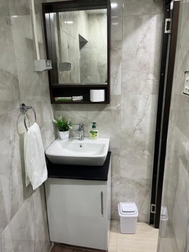 La salle de bains est pourvue d'un lavabo blanc et d'un miroir. dans l'établissement Bula Homestay, à Labasa