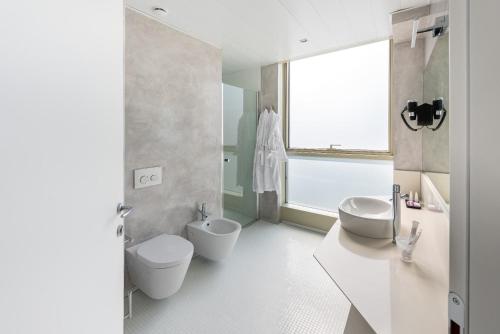 a bathroom with two sinks and a toilet and a window at Carrick Hotel Camogli Portofino Coast in Camogli
