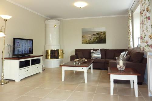 a living room with a couch and a tv at Alte Eiche in Utersum