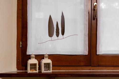 two candles sitting on a shelf in front of a door at Locanda del sorriso b&b in San Quirico dʼOrcia