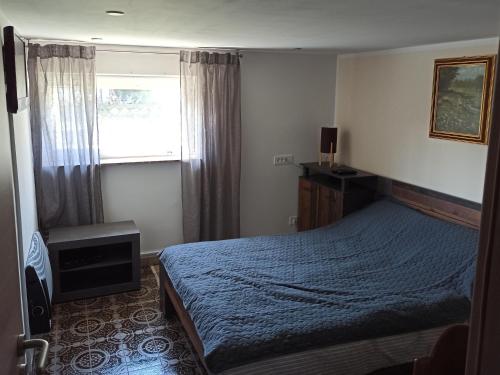 Un dormitorio con una cama azul y una ventana en Family apartments "Hamster" up to 7 persons, en Zgornja Polskava