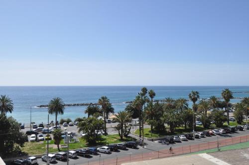 a parking lot with cars parked next to the ocean at Hotel Sole Mare in Sanremo