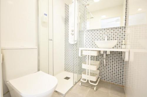 a white bathroom with a toilet and a sink at Apartamentos ALAZUL JRJ in Conil de la Frontera