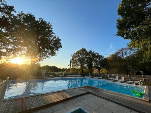 una piscina con puesta de sol en el fondo en n°9. gite 5 Personnes, en Saint-Aubin-de-Nabirat