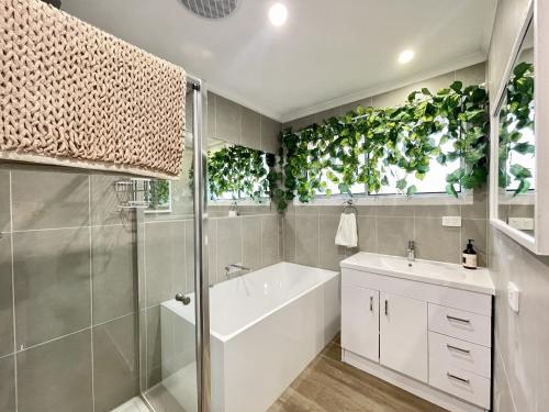 a bathroom with a white tub and a sink at Penlink Lodge - Base To Explore Mornington Peninsula in Langwarrin