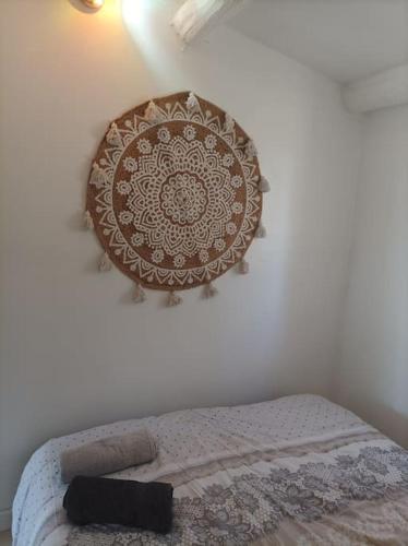 1 cama en un dormitorio con un plato en la pared en n°9. gite 5 Personnes, en Saint-Aubin-de-Nabirat