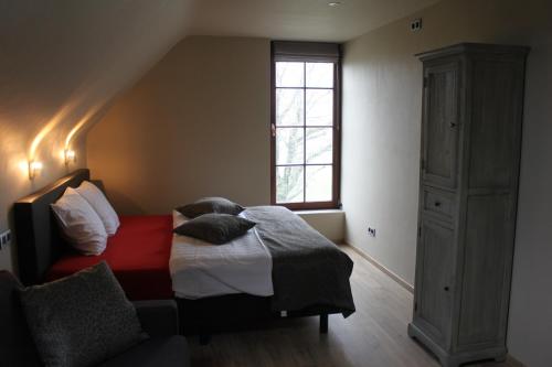 Schlafzimmer mit einem Bett und einem Fenster in der Unterkunft De Landweg in Tielt
