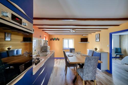 une cuisine et une salle à manger avec une table et des chaises dans l'établissement Vacances en duo près de la mer, au Guilvinec