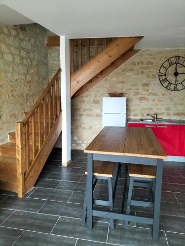 a kitchen with a wooden table and a staircase at Domaine de BELLEVUE in Pouançay