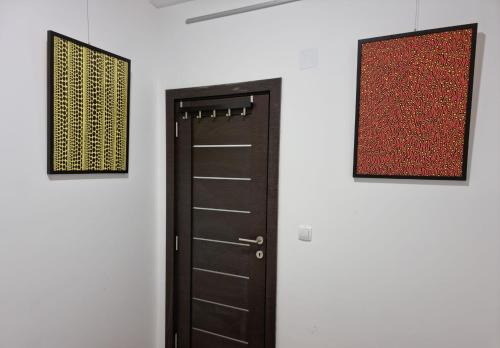 a door in a room with two pictures on the wall at Kusama All New Business Grade Comfort Apartment in Belgrade