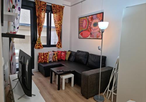 a living room with a black couch and a tv at Kusama All New Business Grade Comfort Apartment in Belgrade