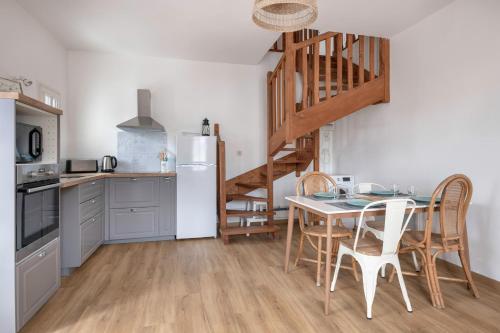 une cuisine avec une table et des chaises ainsi qu'un escalier dans l'établissement Séjour en famille à 400m de la plage, à Sarzeau