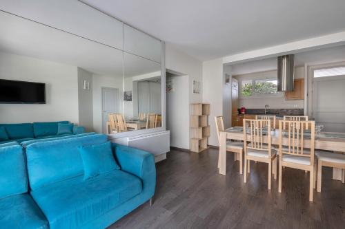 un salon avec un canapé bleu et une table dans l'établissement Appart 4 adultes 2 enfants - Accès plage direct, au Pouliguen