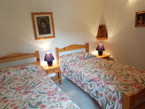 - une chambre avec 2 lits et 2 lampes sur les tables dans l'établissement APPARTEMENT ORO 11- 1 CHAMBRE - REZ DE JARDIN, à Conca