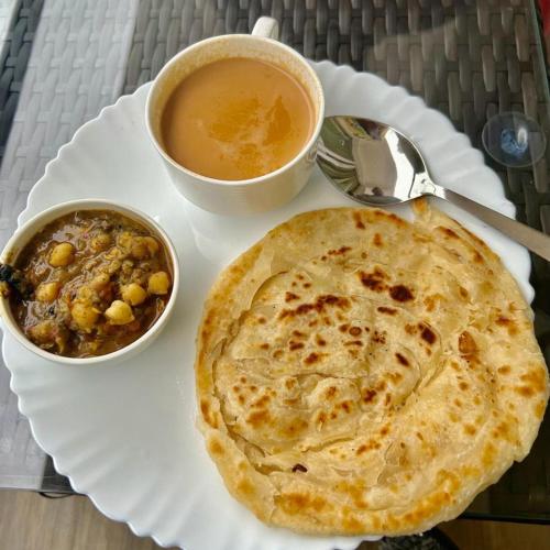 a plate of food with a pie and a cup of coffee at Amaira Resort & Farms - Mirik, West Bengal in Mirik