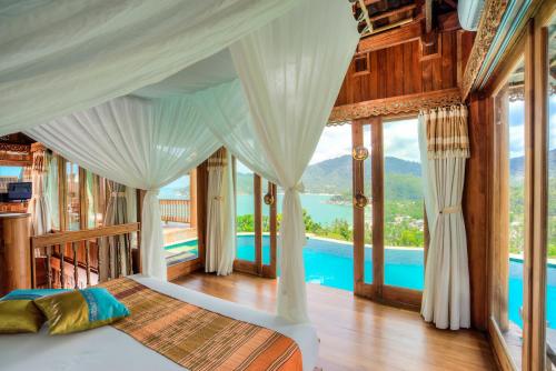 a bedroom with a bed with a view of a pool at Santhiya Koh Phangan Resort and Spa in Thong Nai Pan Noi