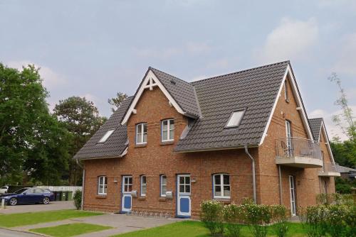 a red brick house with a black roof at Aurelia Haus 1 in Wyk auf Föhr