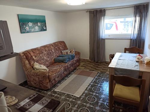 ein Wohnzimmer mit einem Sofa und einem Tisch in der Unterkunft Family apartments "Hamster" up to 7 persons in Zgornja Polskava