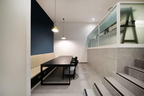 a dining room with a black table and chairs at Staz Hotel Ulsan in Ulsan