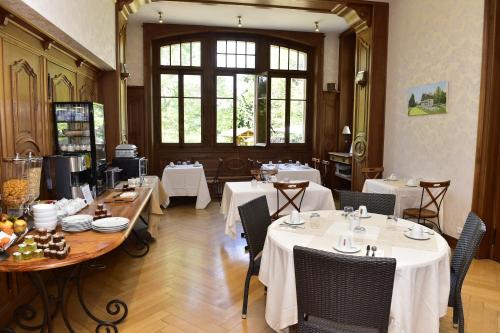 PublierにあるLe Manoir du Golfのテーブルと椅子(白いテーブルクロス付)が備わるレストラン